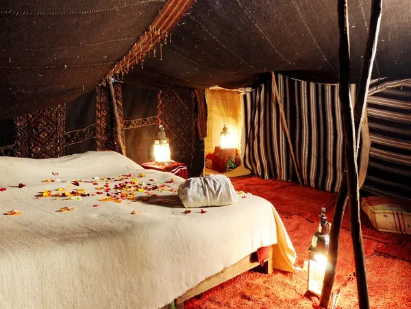 A bed under a Berber tent with lanterns