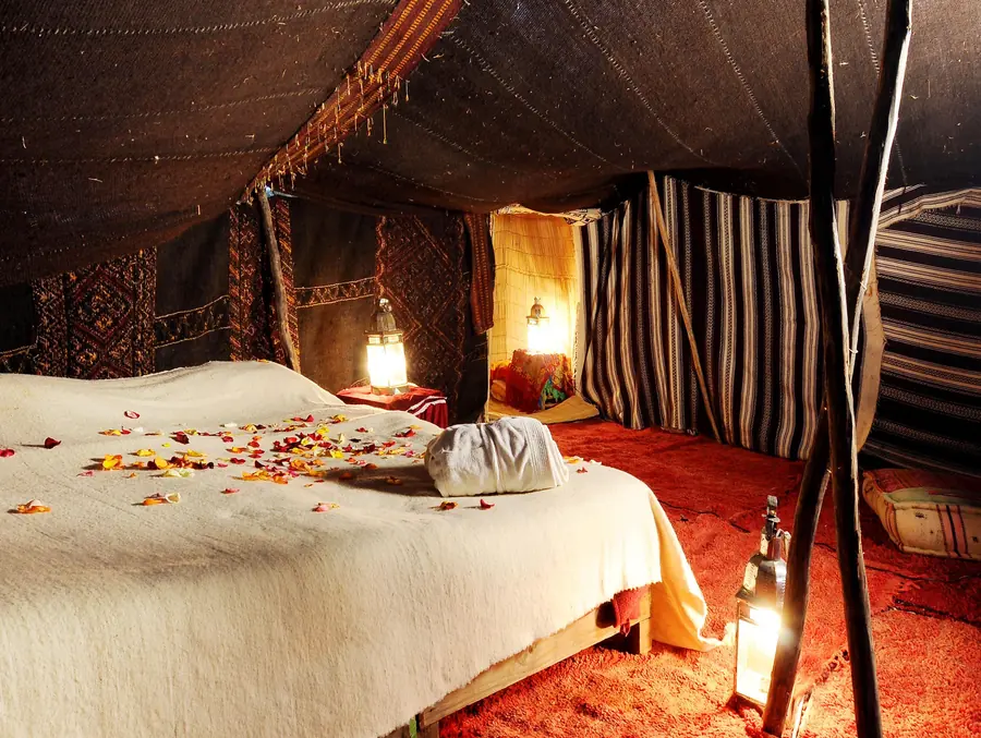 A bed under a Berber tent with lanterns