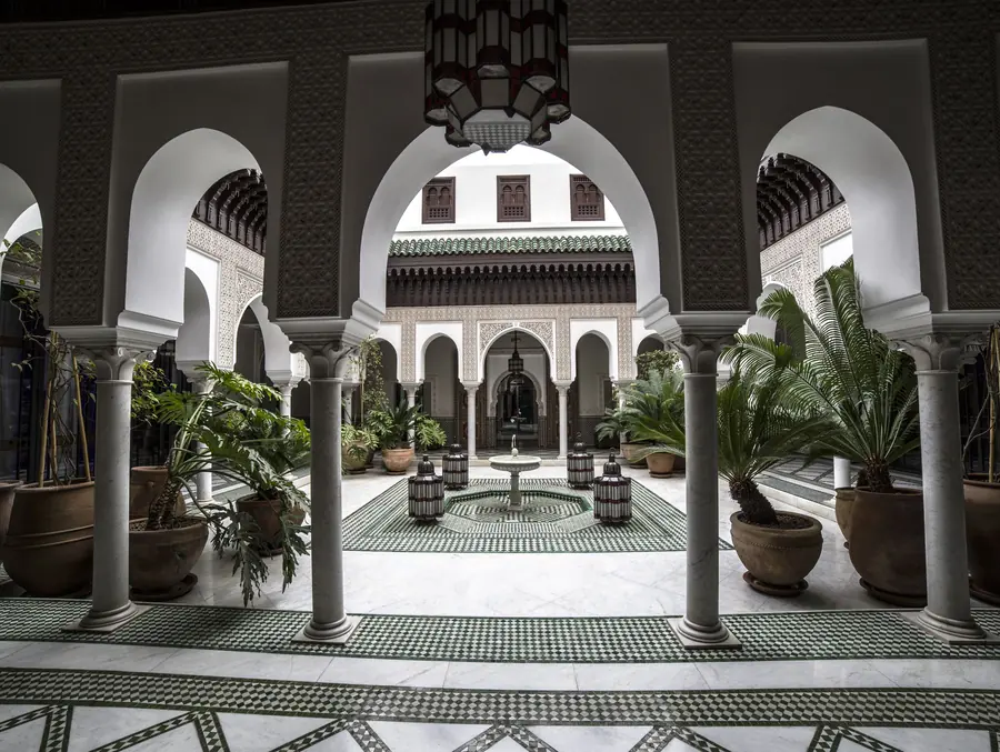 A courtyard with a fountain and carved arches