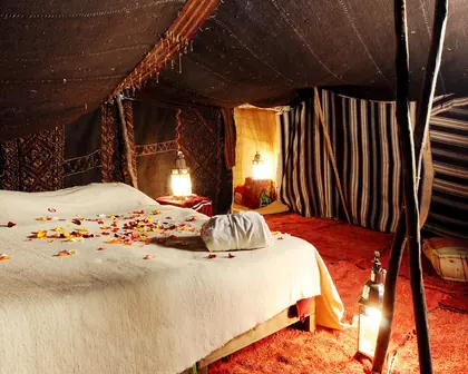 A bed under a Berber tent with lanterns